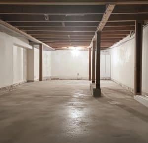 Empty basement space with exposed beams and concrete floor, illustrating potential for waterproofing and foundation repair services by Ohio State Waterproofing.