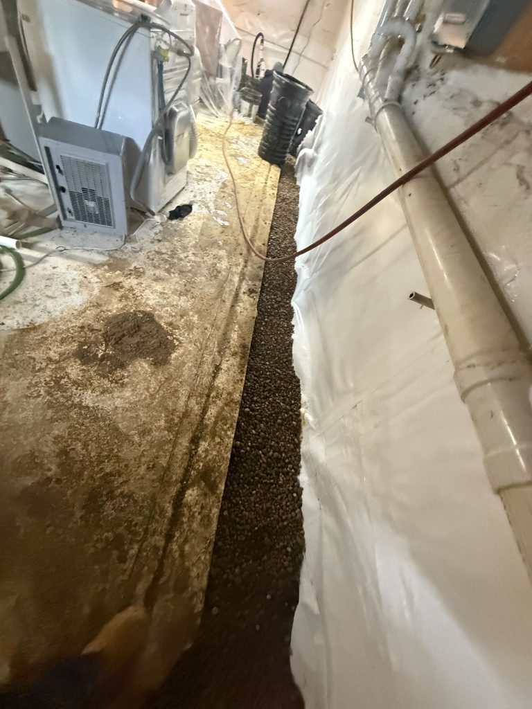 Basement interior showing gravel drainage system and waterproofing materials, highlighting moisture control solutions for homes in Youngstown, Ohio.