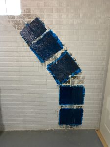 Foundation repair wall with blue waterproofing sealant applied in patches, illustrating treatment for water damage prevention.