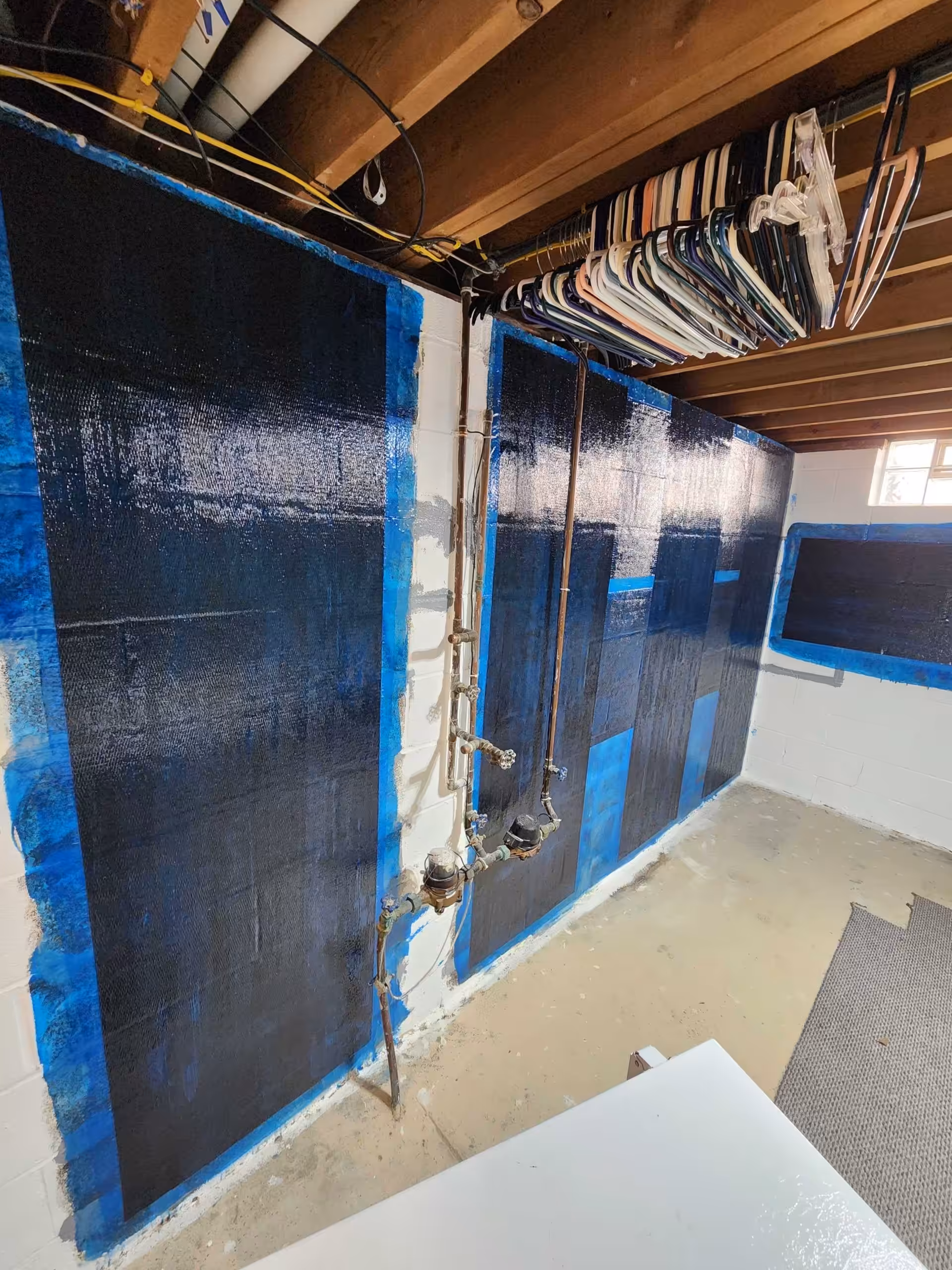 Basement waterproofing wall treatment applied to concrete foundation walls to help prevent moisture damage and structural issues